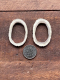 Pair of handcrafted elk antler hoop earrings shown with a quarter for size